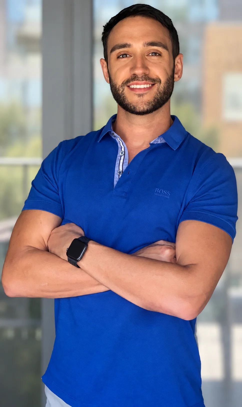 Filip Brnadic, smiling with his arms crossed in a blue polo shirt.